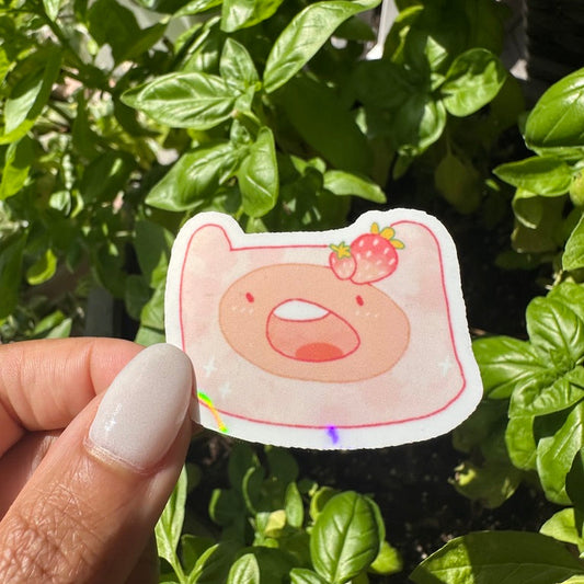 A die-cut holographic sticker of the cartoon character Finn the Human with a strawberry. Cute Adventure time sticker. Stickers_for_water_bottle_laptop_sticker_cute_sticker_cool_sticker_honeycraft_sticker